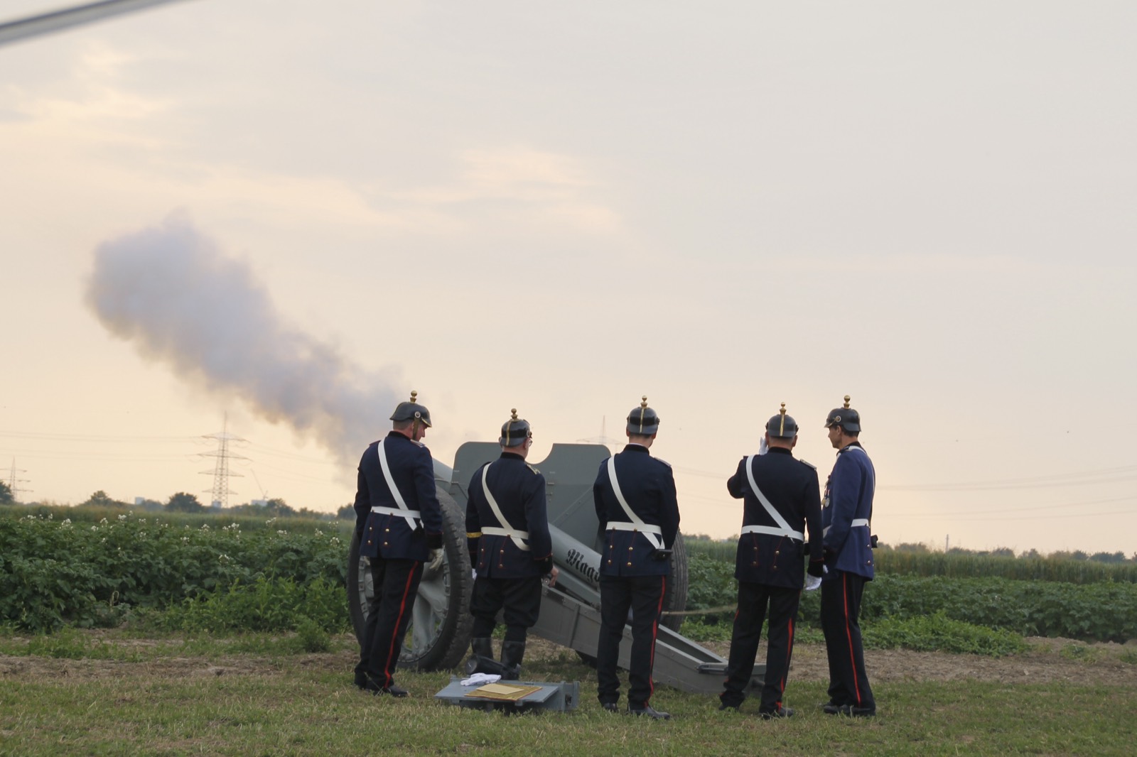 Artilleristen des Corps böllern in der Abenddämmerung, über dem Geschütz steht eine Rauchwolke